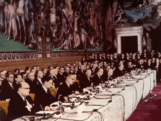 Photo prise lors du traité de Rome. Des politiques sont assis autour d'une table.