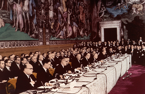 Photo prise lors du traité de Rome. Des politiques sont assis autour d'une table.