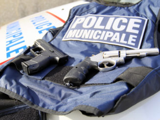 un gilet par balle de la police municipale avec des armes posées dessus
