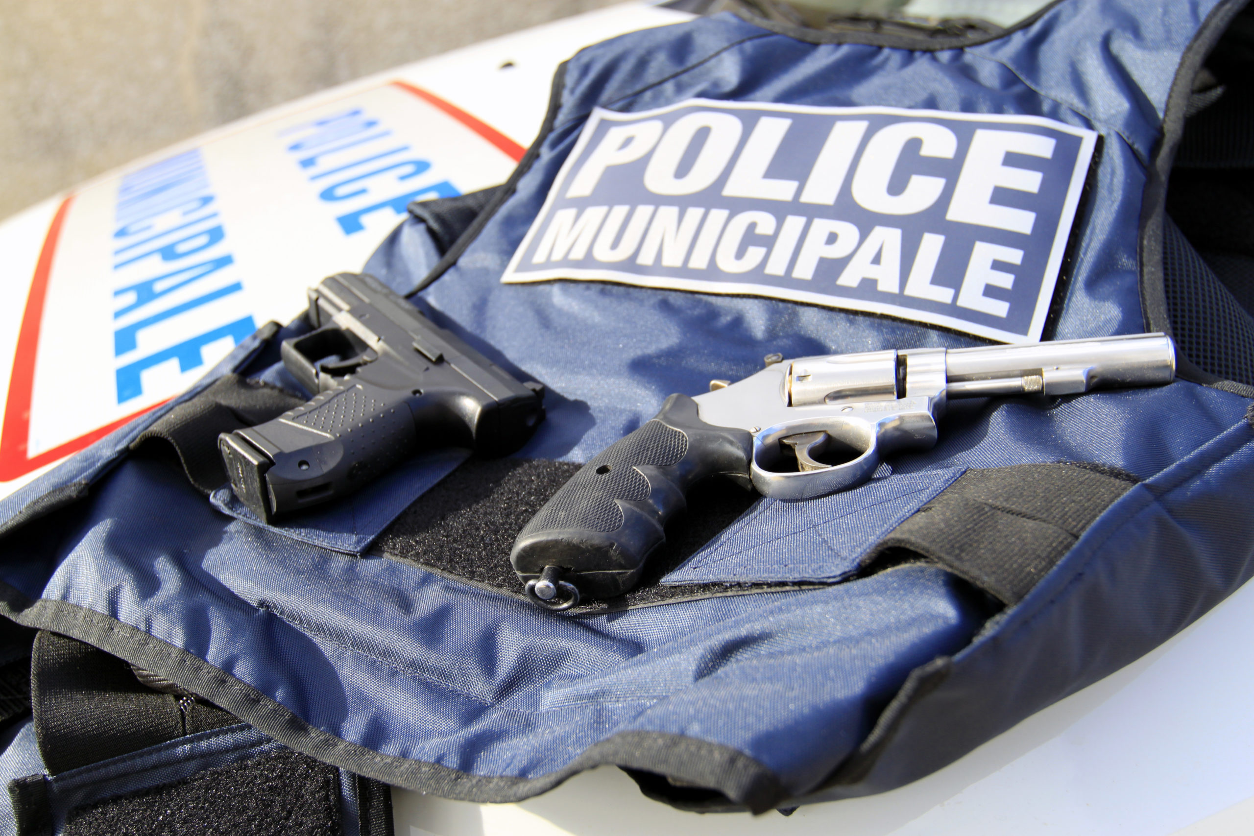 un gilet par balle de la police municipale avec des armes posées dessus