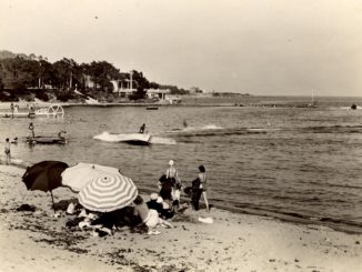 une plage avec des parasols et des gens, photos en noir et blanc