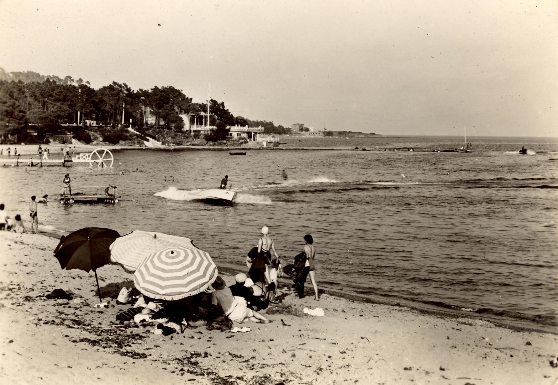 une plage avec des parasols et des gens, photos en noir et blanc